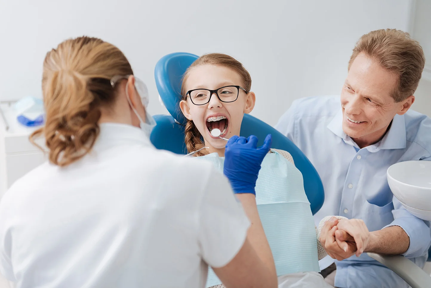 A young patient and her parent with the dental team at Anamosa Dental Associates