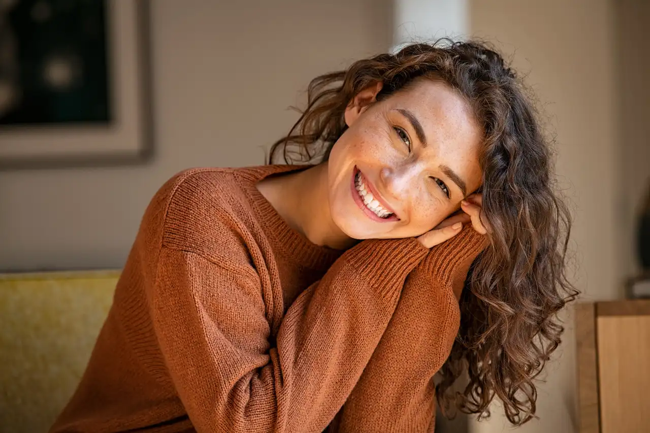 A woman smiling confidently after cosmetic dental treatment