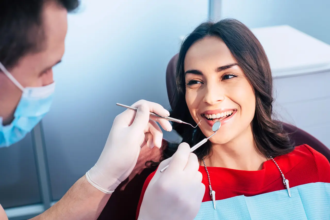 A dentist examining a smiling patient during a routine visit