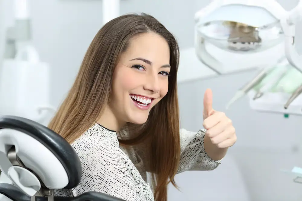 A patient giving a thumbs up after periodontal care