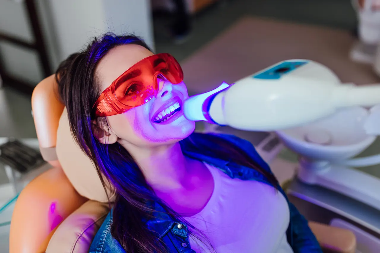 A patient having her teeth whitened with a professional whitening light